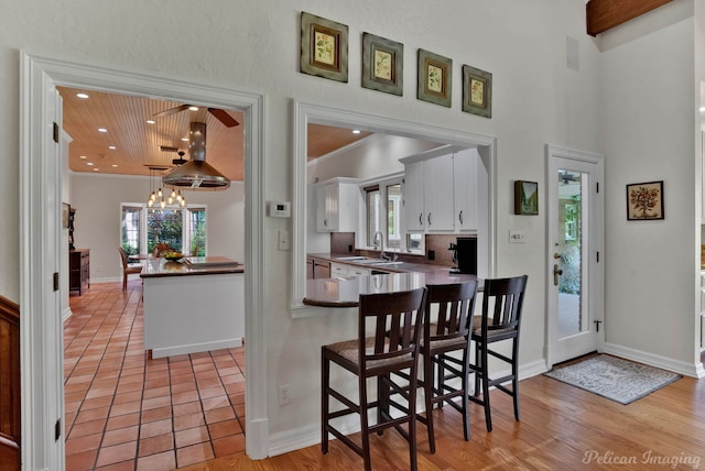 6706 Querbes Dr, Shreveport, LA 71106 - kitchen featuring white cabinets, crown molding, a kitchen bar, recessed lighting, and dark countertops