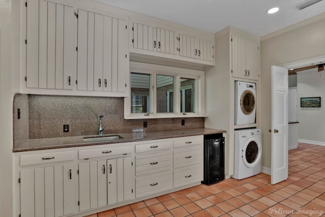 6706 Querbes Dr, Shreveport, LA 71106 - kitchen with stacked washer / dryer, a sink, tasteful backsplash, light tile patterned floors, and dark stone countertops
