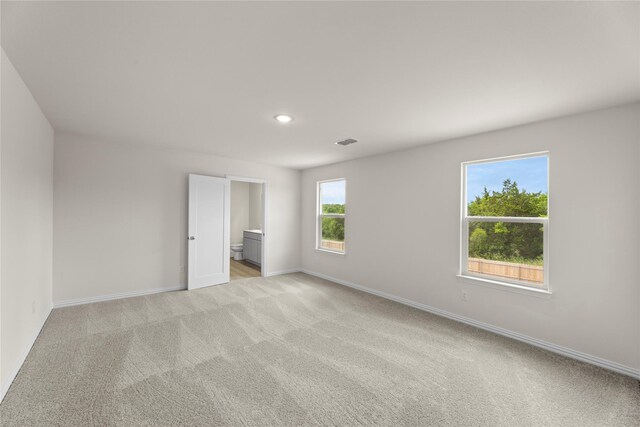 120 Doma Ave, Greenville, TX 75402 - unfurnished bedroom featuring light carpet, ensuite bathroom, and recessed lighting