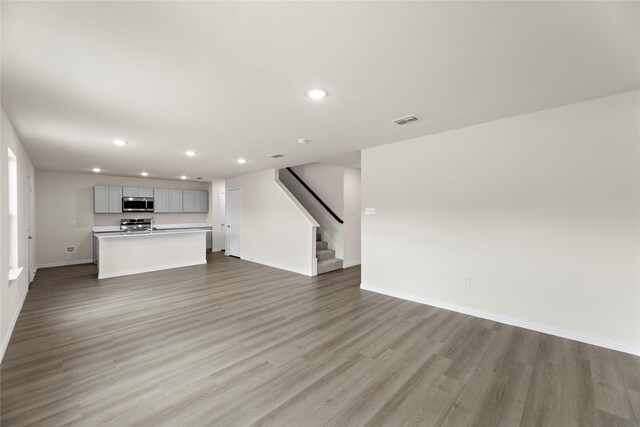 120 Doma Ave, Greenville, TX 75402 - kitchen featuring electric range oven, white microwave, gray cabinets, a breakfast bar area, and recessed lighting