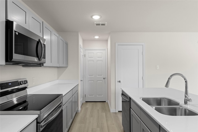 120 Doma Ave, Greenville, TX 75402 - kitchen with stainless steel appliances, gray cabinetry, light wood-style floors, light countertops, and recessed lighting