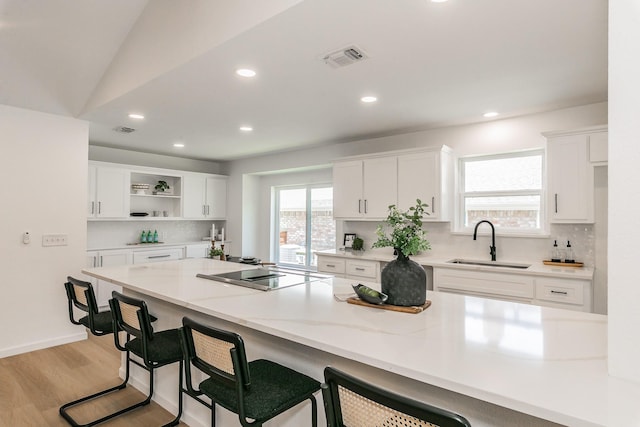 2505 Kelsey Dr, Plano, TX 75075 - kitchen with a sink, black electric stovetop, decorative backsplash, open shelves, and white cabinets