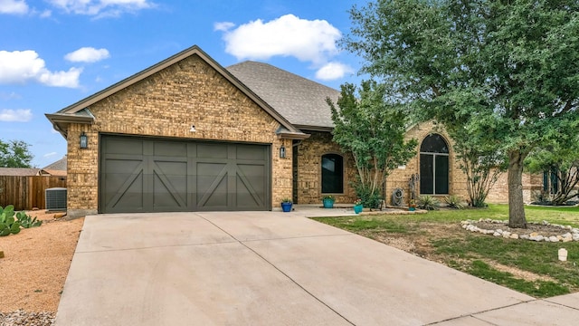 110 Emilie Ct, Weatherford, TX 76087 - view of front facade featuring a garage, brick siding, driveway, central AC unit, and roof with shingles