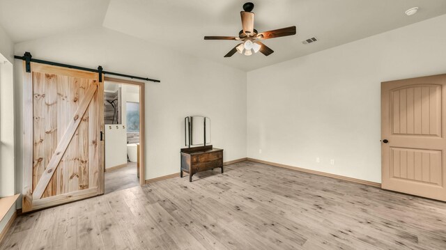 110 Emilie Ct, Weatherford, TX 76087 - empty room featuring a barn door, wood finished floors, lofted ceiling, a ceiling fan, and baseboards