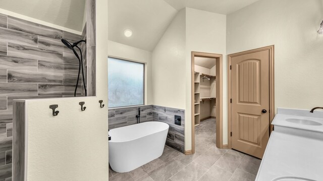 110 Emilie Ct, Weatherford, TX 76087 - full bathroom featuring a walk in shower, vaulted ceiling, a freestanding tub, vanity, and tile walls