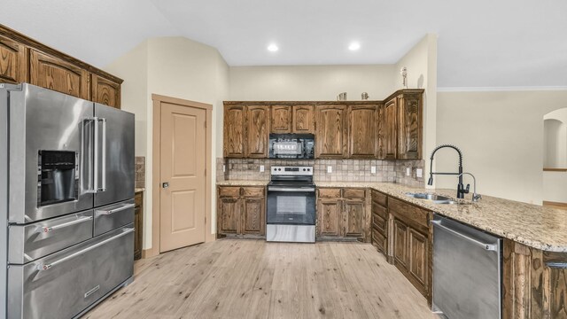 110 Emilie Ct, Weatherford, TX 76087 - kitchen featuring appliances with stainless steel finishes, a sink, a peninsula, light wood-style floors, and ornamental molding