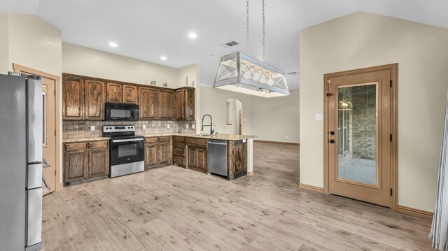110 Emilie Ct, Weatherford, TX 76087 - kitchen with stainless steel appliances, a peninsula, a sink, light wood-style flooring, and lofted ceiling