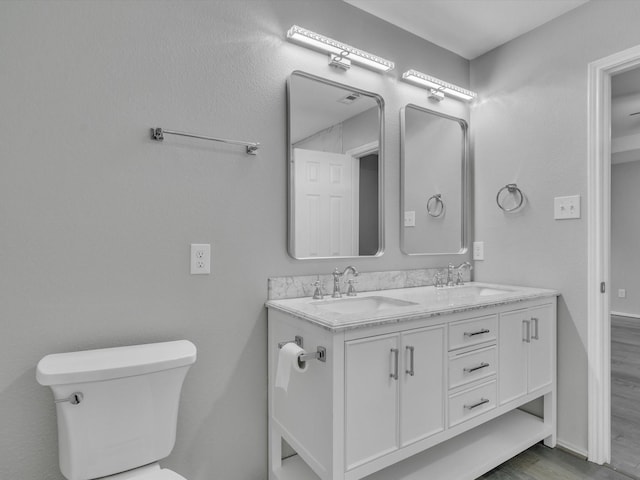 401 Iron Ore Trl, Fort Worth, TX 76131 - bathroom with toilet, wood finished floors, double vanity, and baseboards