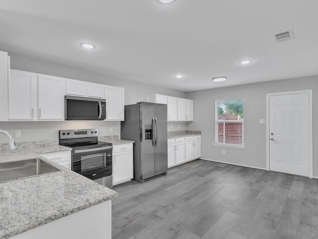 401 Iron Ore Trl, Fort Worth, TX 76131 - kitchen featuring stainless steel appliances, a sink, white cabinetry, light wood-style flooring, and recessed lighting