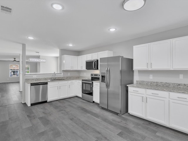 401 Iron Ore Trl, Fort Worth, TX 76131 - kitchen featuring appliances with stainless steel finishes, a sink, white cabinetry, wood finished floors, and recessed lighting
