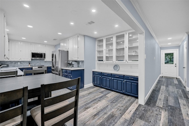 912 Kiowa Dr W, Lake Kiowa, TX 76240 - kitchen featuring blue cabinetry, appliances with stainless steel finishes, white cabinetry, light wood finished floors, and decorative backsplash