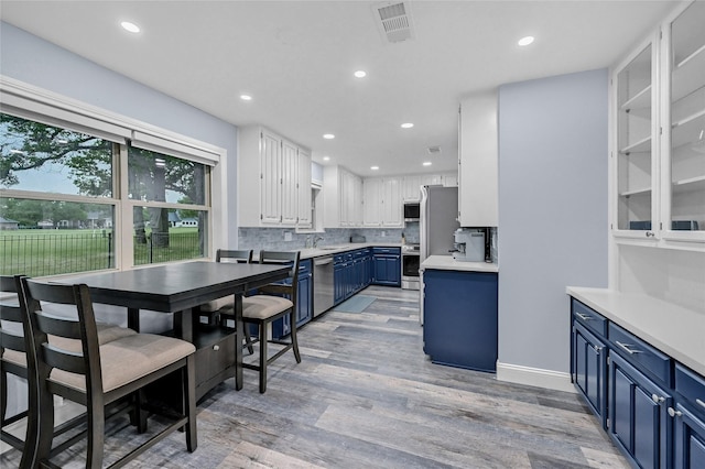 912 Kiowa Dr W, Lake Kiowa, TX 76240 - kitchen featuring blue cabinetry, appliances with stainless steel finishes, a sink, white cabinets, and decorative backsplash