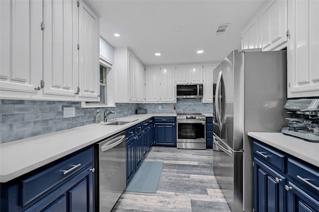 912 Kiowa Dr W, Lake Kiowa, TX 76240 - kitchen featuring blue cabinets, stainless steel appliances, white cabinets, backsplash, and light wood-type flooring