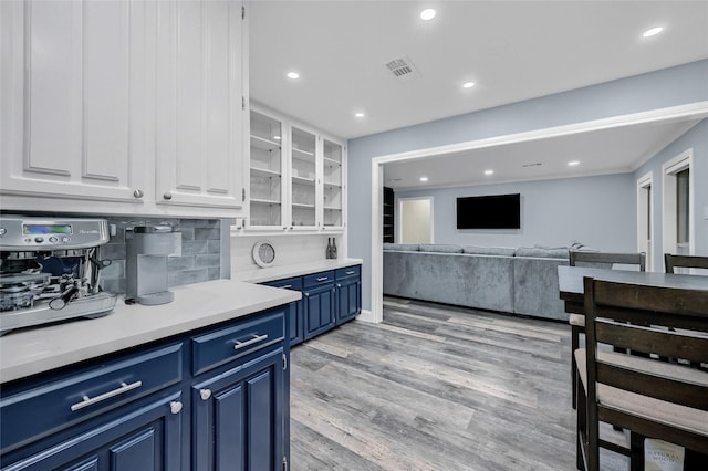 912 Kiowa Dr W, Lake Kiowa, TX 76240 - kitchen with blue cabinets, white cabinetry, light countertops, light wood-type flooring, and tasteful backsplash