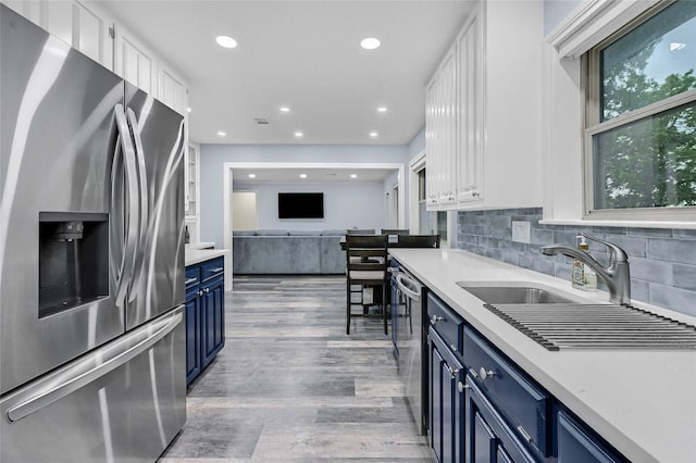 912 Kiowa Dr W, Lake Kiowa, TX 76240 - kitchen with stainless steel appliances, blue cabinetry, light wood-type flooring, light countertops, and white cabinets