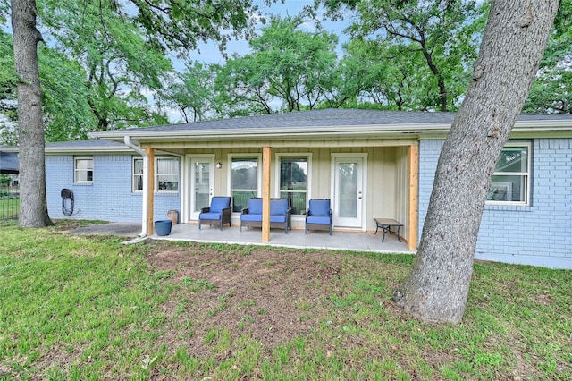 912 Kiowa Dr W, Lake Kiowa, TX 76240 - rear view of house with brick siding, a patio, a yard, and board and batten siding