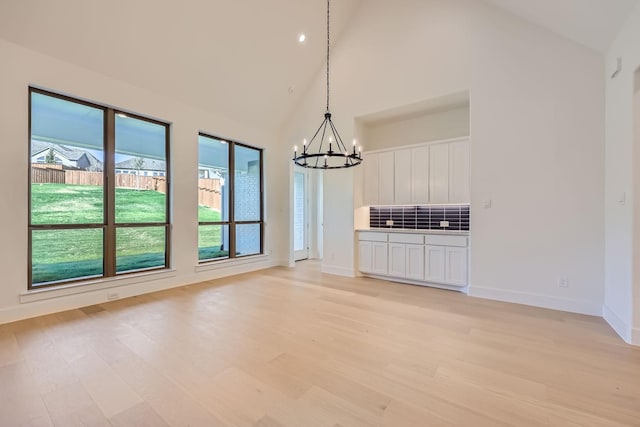 180 Shoreview Dr, Rhome, TX 76078 - unfurnished dining area with a chandelier, light wood-type flooring, high vaulted ceiling, and baseboards