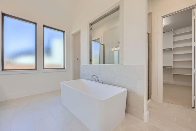 180 Shoreview Dr, Rhome, TX 76078 - bathroom with a stall shower, a freestanding tub, tile patterned floors, a walk in closet, and baseboards