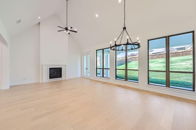 180 Shoreview Dr, Rhome, TX 76078 - unfurnished living room featuring a chandelier, high vaulted ceiling, light wood-type flooring, a fireplace, and baseboards