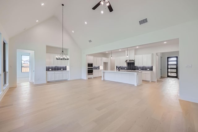 180 Shoreview Dr, Rhome, TX 76078 - unfurnished living room featuring high vaulted ceiling, recessed lighting, a chandelier, ceiling fan, and light wood-type flooring