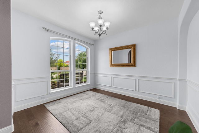 5776 Civetta Ct, Frisco, TX 75035 - unfurnished dining area featuring a chandelier, wood finished floors, a wainscoted wall, arched walkways, and a decorative wall