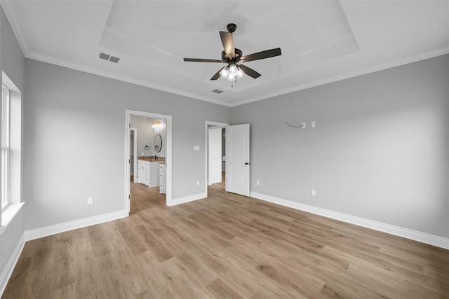 313 Crye Cir, Robinson, TX 76706 - unfurnished bedroom with a raised ceiling, light wood-style floors, ornamental molding, baseboards, and ensuite bathroom