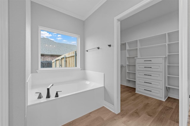 313 Crye Cir, Robinson, TX 76706 - bathroom with ornamental molding, a spacious closet, a bath, wood finished floors, and baseboards