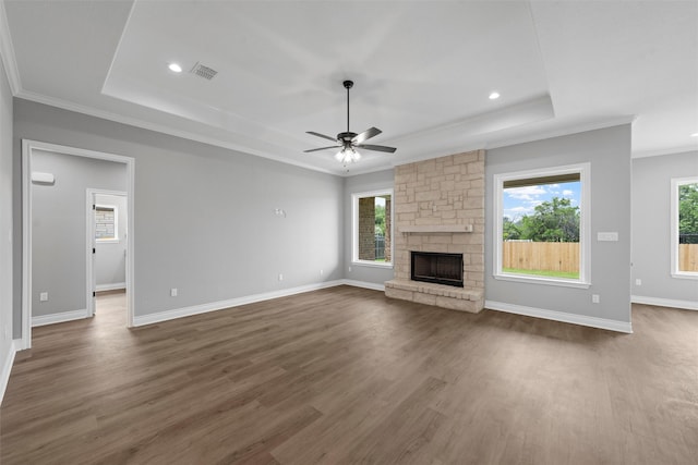 313 Crye Cir, Robinson, TX 76706 - unfurnished living room featuring a raised ceiling, a ceiling fan, crown molding, a fireplace, and dark wood finished floors
