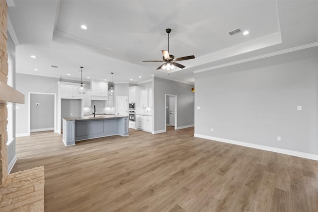 313 Crye Cir, Robinson, TX 76706 - unfurnished living room featuring a tray ceiling, a ceiling fan, recessed lighting, baseboards, and light wood-style floors