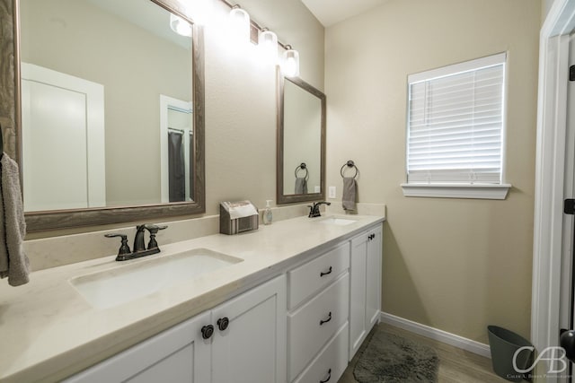 6833 Inverness St, Abilene, TX 79606 - full bath with double vanity, baseboards, and wood finished floors