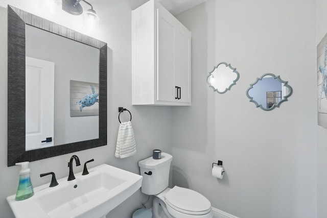 7747 Barber Ranch Rd, Fort Worth, TX 76126 - half bathroom featuring a sink, toilet, and baseboards
