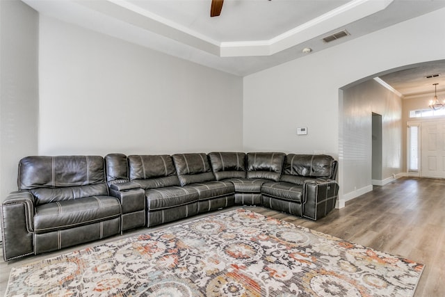 7209 Coventry Cir, North Richland Hills, TX 76182 - living area featuring arched walkways, wood finished floors, crown molding, a ceiling fan, and a tray ceiling
