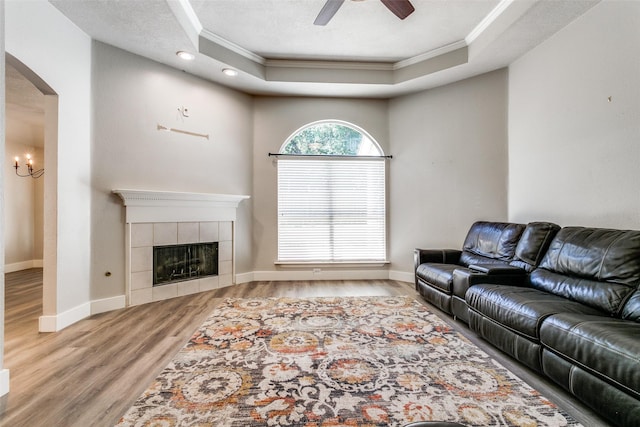 7209 Coventry Cir, North Richland Hills, TX 76182 - living room with crown molding, a raised ceiling, wood finished floors, a ceiling fan, and arched walkways