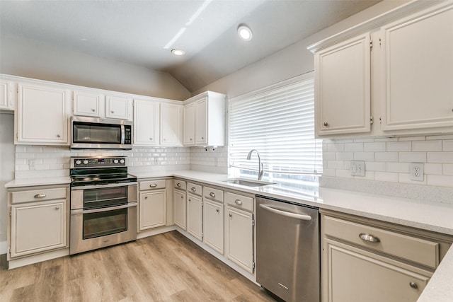 7209 Coventry Cir, North Richland Hills, TX 76182 - kitchen featuring stainless steel appliances, a sink, vaulted ceiling, light countertops, and light wood-style floors