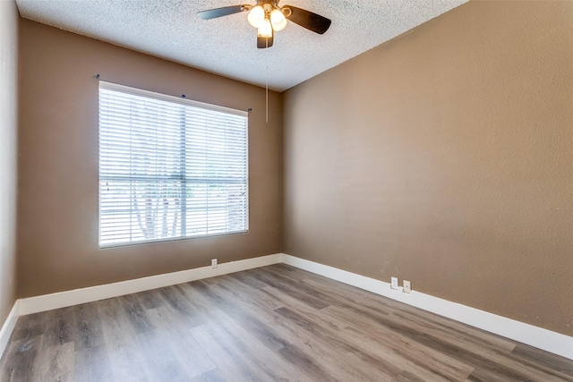 7209 Coventry Cir, North Richland Hills, TX 76182 - empty room featuring a textured ceiling, wood finished floors, a ceiling fan, and baseboards