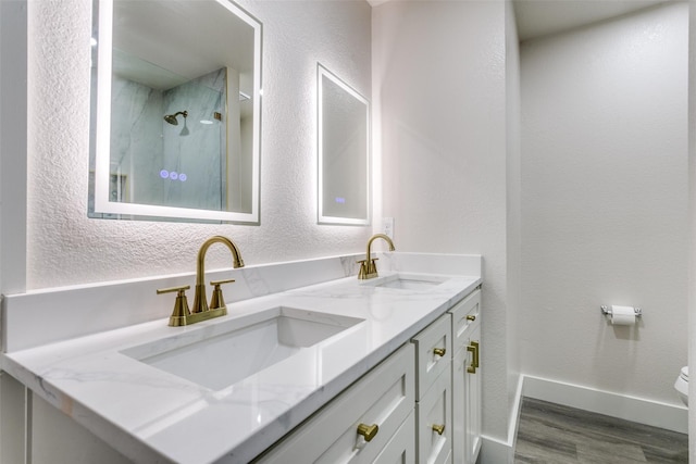 7209 Coventry Cir, North Richland Hills, TX 76182 - full bath featuring wood finished floors, a marble finish shower, double vanity, a textured wall, and toilet