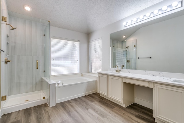 7209 Coventry Cir, North Richland Hills, TX 76182 - full bathroom with a shower stall, a textured ceiling, wood finished floors, a bath, and double vanity