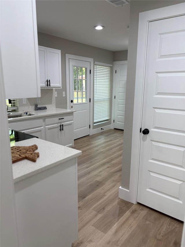 3214 51st St, Dallas, TX 75216 - kitchen with light wood-style floors, white cabinets, recessed lighting, and light stone countertops