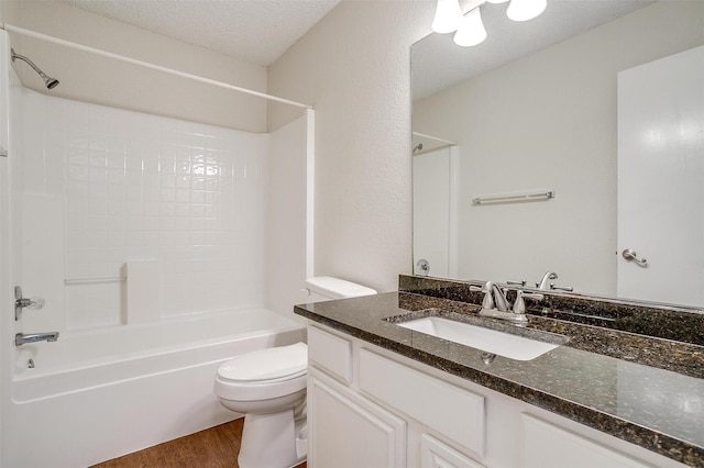 10832 Cobblestone Dr, Benbrook, TX 76126 - bathroom featuring wood finished floors, vanity, toilet,  shower combination, and a textured ceiling