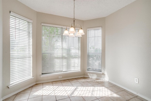 10832 Cobblestone Dr, Benbrook, TX 76126 - unfurnished dining area with a chandelier, a textured ceiling, tile patterned flooring, and baseboards