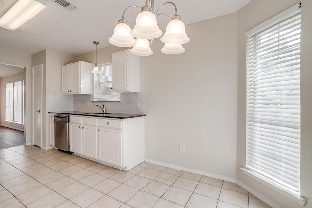 10832 Cobblestone Dr, Benbrook, TX 76126 - kitchen with dark countertops, stainless steel dishwasher, a sink, plenty of natural light, and a textured ceiling