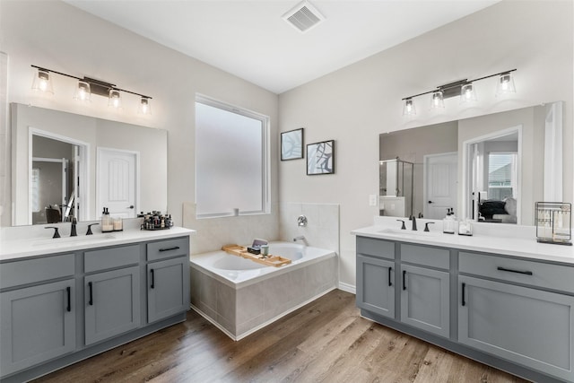 1412 Inks Dr, Desoto, TX 75115 - full bath featuring a stall shower, wood finished floors, two vanities, and a garden tub