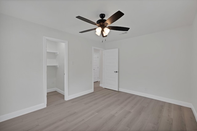 3022 50th St, Dallas, TX 75216 - unfurnished bedroom with light wood-style flooring, a spacious closet, baseboards, and a ceiling fan