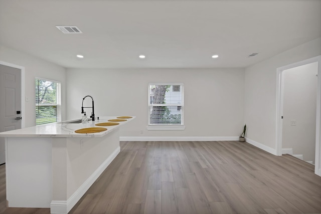 3022 50th St, Dallas, TX 75216 - kitchen featuring wood finished floors, recessed lighting, a sink, a kitchen island with sink, and baseboards