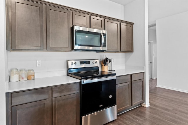 1416 Old Trail Rd, Royse City, TX 75189 - kitchen with appliances with stainless steel finishes, dark wood finished floors, light countertops, dark brown cabinetry, and baseboards