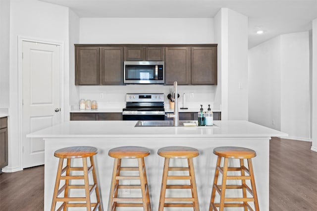1416 Old Trail Rd, Royse City, TX 75189 - kitchen featuring stainless steel appliances, dark wood-style flooring, dark brown cabinetry, a sink, and light countertops