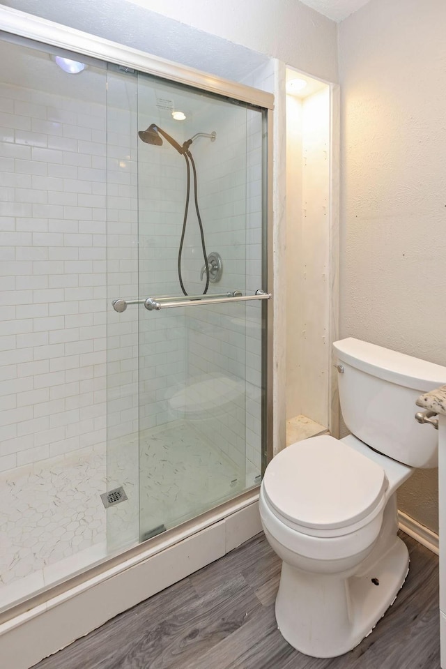 745 Cambridge Dr, Plano, TX 75023 - bathroom featuring wood finished floors, a shower stall, and toilet