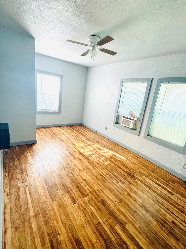 301 Beckham St E, Sulphur Springs, TX 75482 - spare room featuring wood finished floors, a textured ceiling, a ceiling fan, baseboards, and cooling unit