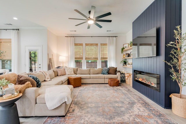 391 E Lamar St, Royse City, TX 75189 - living area featuring ceiling fan, ornamental molding, healthy amount of natural light, a large fireplace, and light wood-style floors
