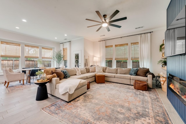 391 E Lamar St, Royse City, TX 75189 - living area with healthy amount of natural light, ceiling fan, a fireplace, light wood-type flooring, and crown molding